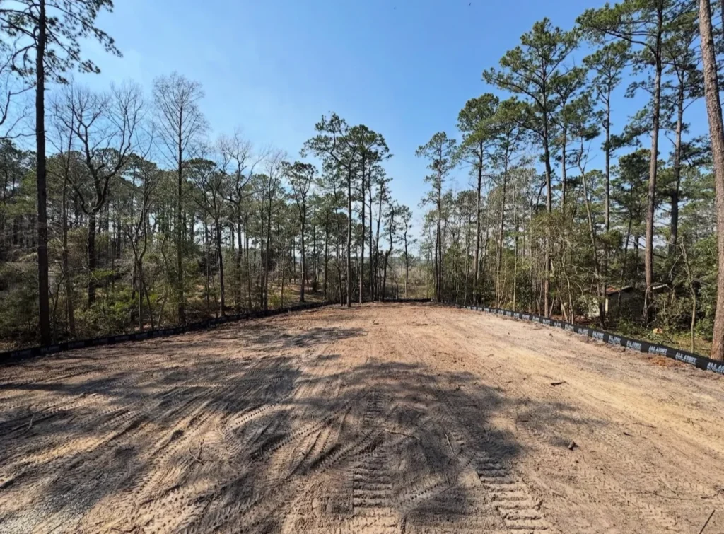 Large open field and woodland area pre-clearing for major construction project.